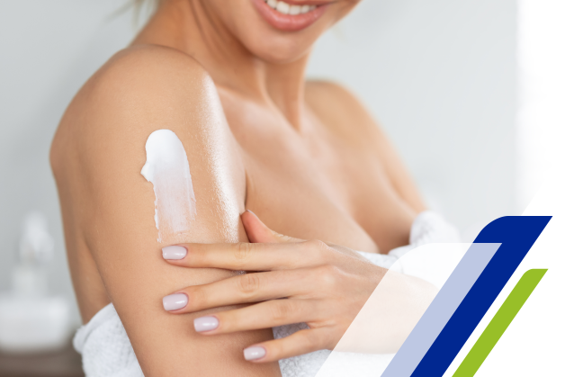 uma mulher passando hidratante no braço e sorrindo