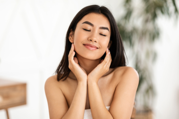 Mulher relaxada e com a pele radiante após aprender a como fazer skincare da forma correta.